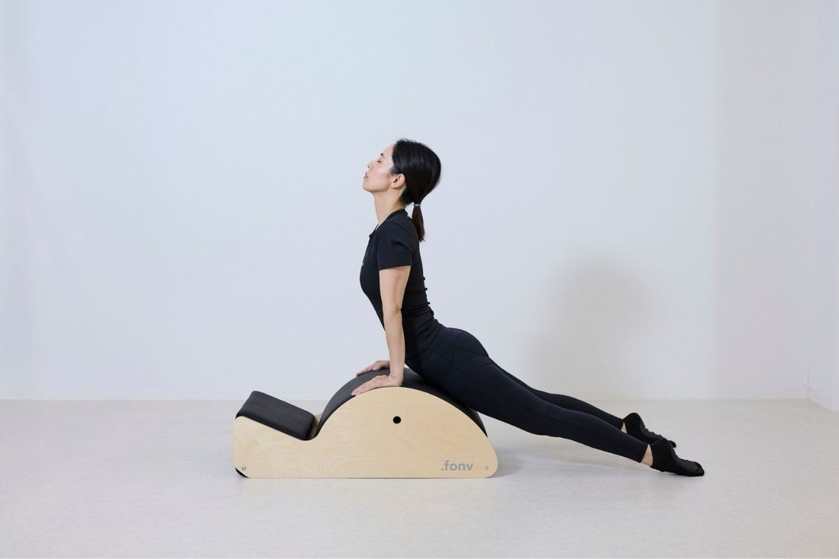 A Pilates exercise at BLACK CAT: a back extension over a spine corrector.
